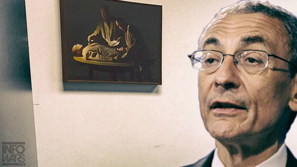 John Podesta, bývalý šéf volební kampaně Hillary Clinton na fotografii ze svého domu. Na zdi je obraz s kanibaly.